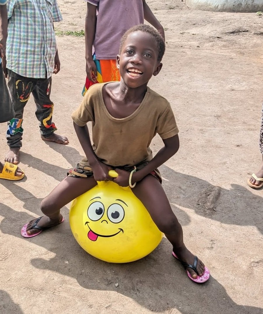 Petit garçon souriant jouant sur un ballon
